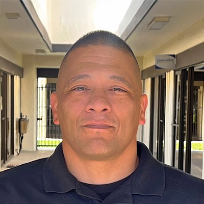 Ernie Cabrera Rehab Technician In Collared Shirt Looking Stern