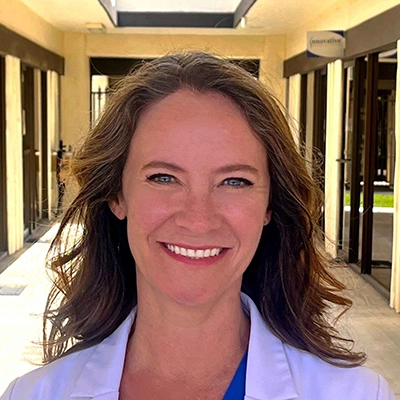 Nurse Practitioner Kristin McCluskey Smiling In Lab Coat