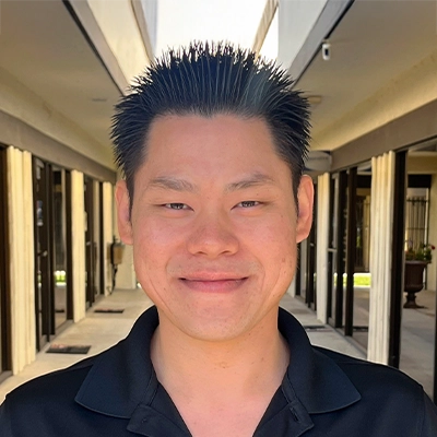 Rehab Technician Peter Lao Smiling In Collared Shirt